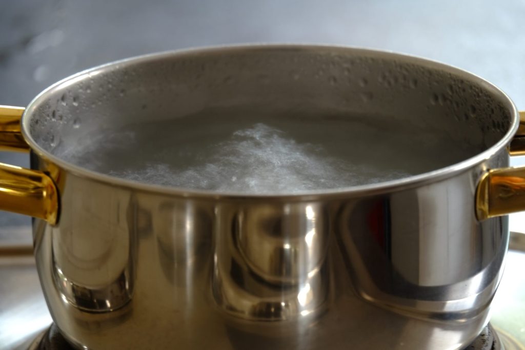 A pot of water boiling on the hob